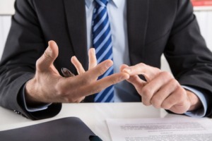 Business Mann zählt Vorteile und Nachteile an den Fingern ab