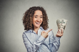 happy successful young business woman holding dollar bills